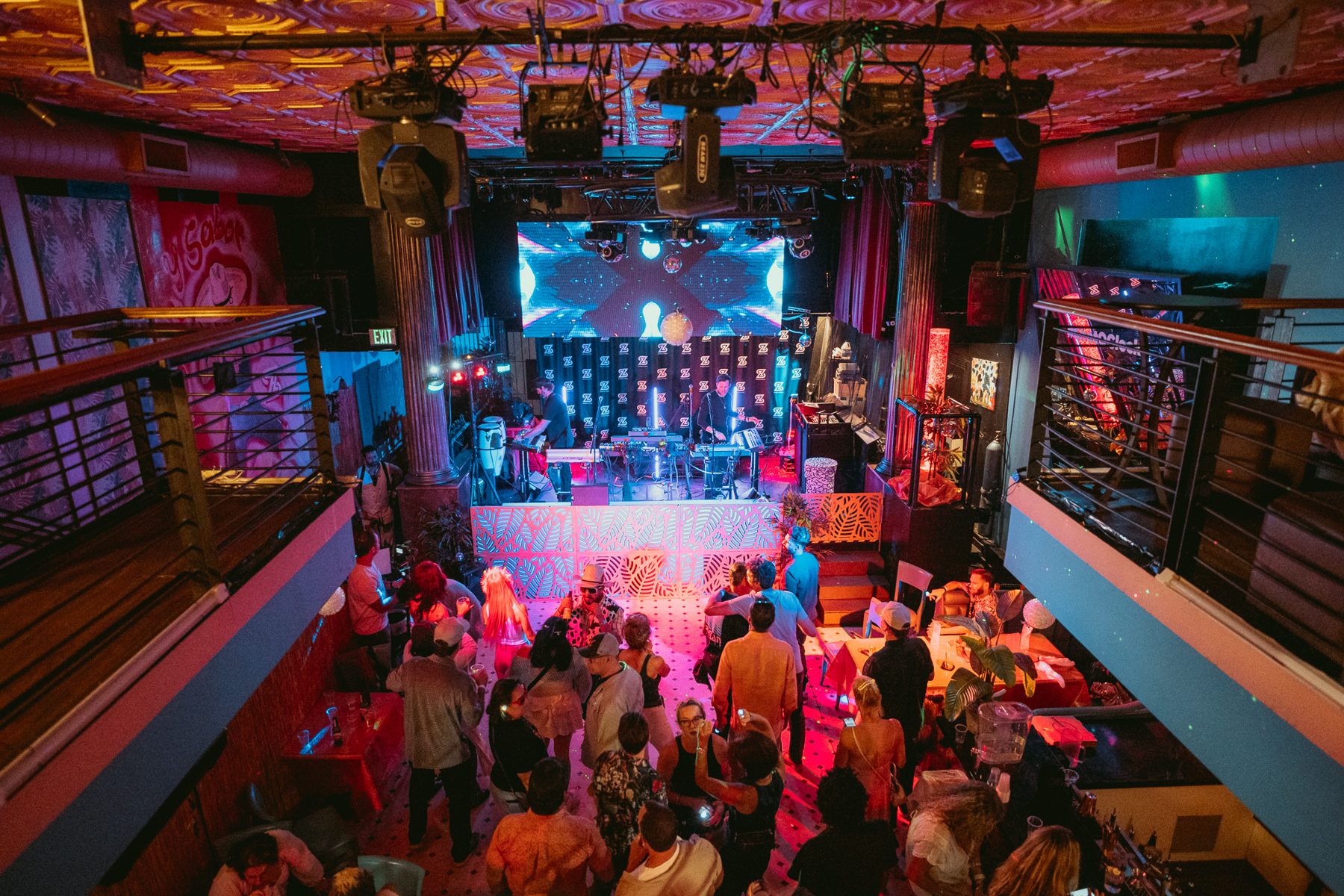 A packed venue glowing pink during a set